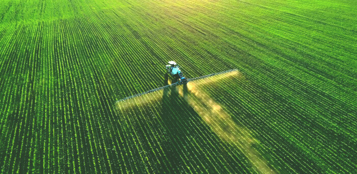 Tractor with sprayer in field